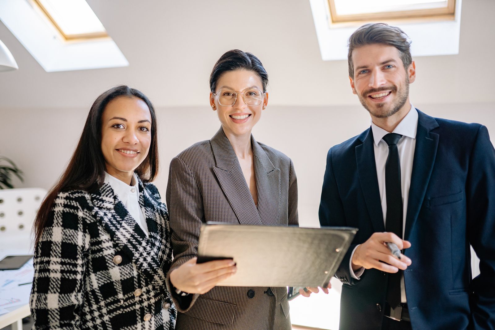Three UTS professionals standing together in a bright office.